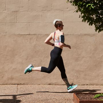 a person Milers running on a sidewalk while listening to music