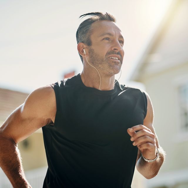 running workout, neighborhood man and outdoor fitness training for marathon, healthy lifestyle and wellness. mature guy listening to music in morning cardio exercise, strong body and sunny motivation