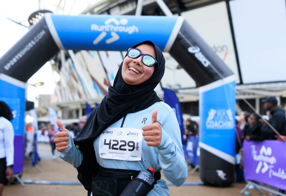 participant at a running event posing with thumbs up