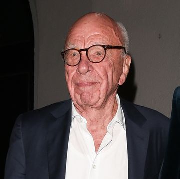 rupert murdoch wears a suit jacket, a white collared shirt that is unbuttoned at the neck and tortoise brown glasses
