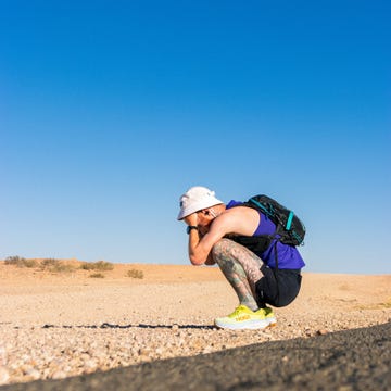 a man squatting on a road