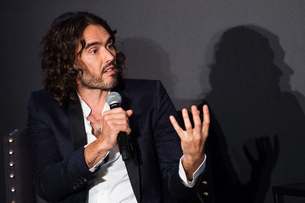 russell brand speaks on a microphone