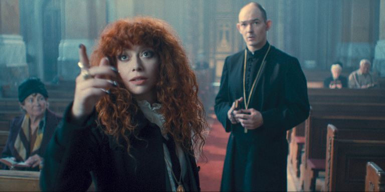 natasha lyonne pictured pointing at something in a church while a confused priest looks on behind her in russian doll season 2