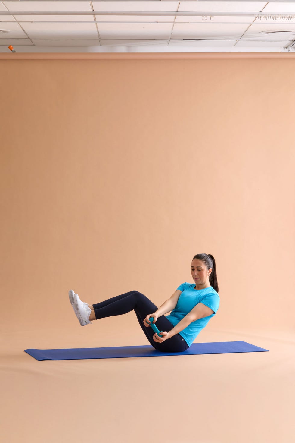 russian twist person performing an exercise on a fitness mat with dumbbells