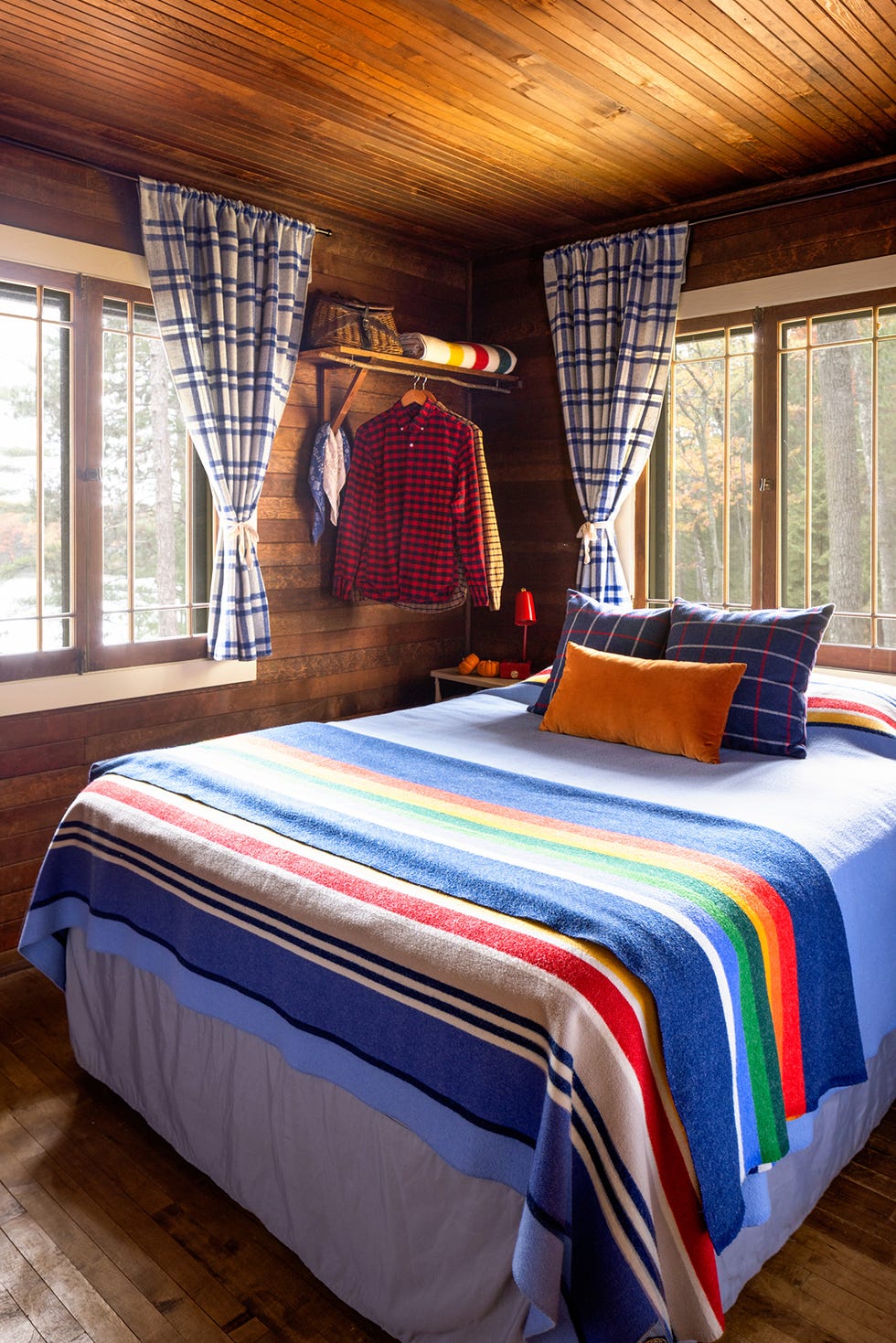 a wood guest room with colorful bedding