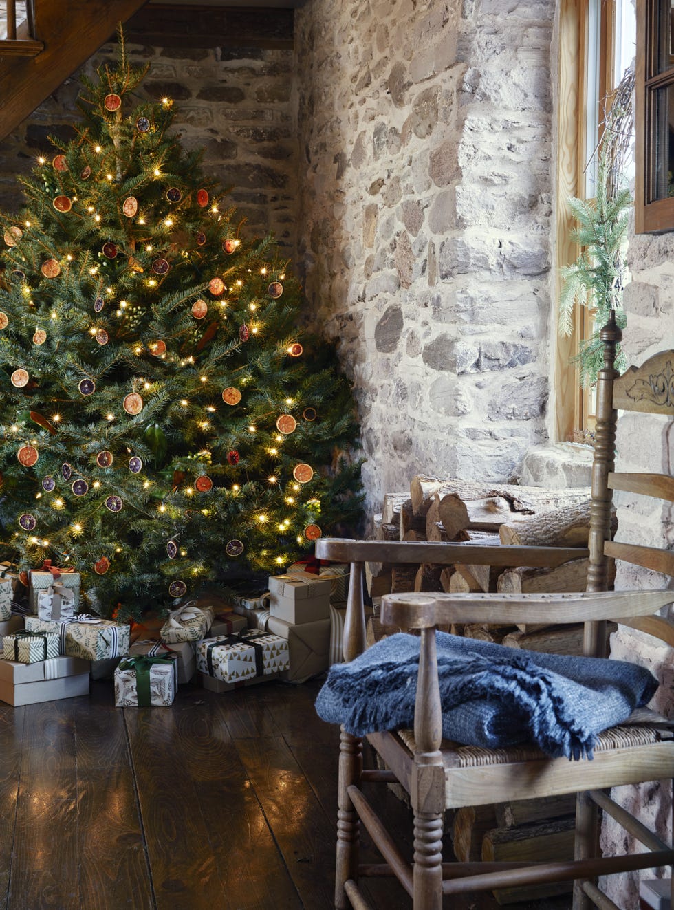 christmas tree under the stairs of stone house decorated with loads of dried oranges