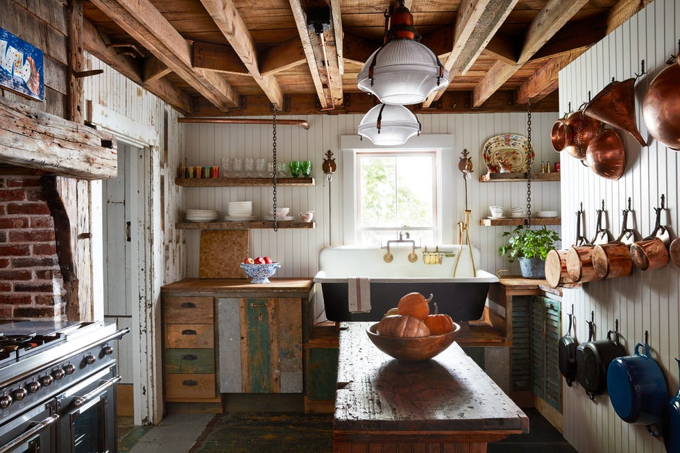 kitchen designer ken fulk touches up the cook space in his 241 year old cape cod featuring reclaimed wood, repurposed island, trough sink, factory lights, copper cookware, and mismatchedtableware