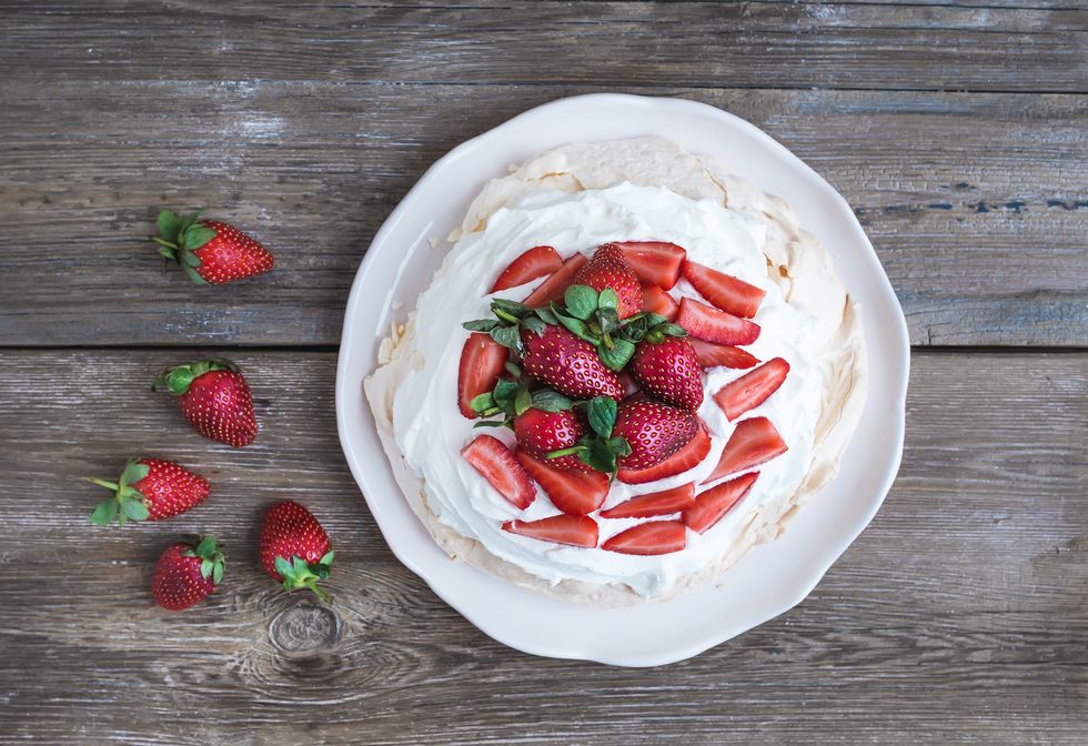 rustic pavlova cake with fresh strawberries and whipped cream