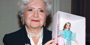 barbie creator ruth handler holding a doll inside a box and smiling for a photo