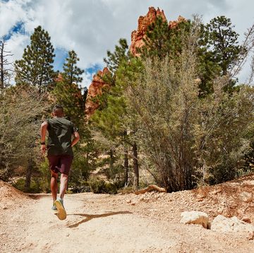 man running Klettverschluss down a dusty trail in bryce canyon