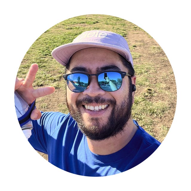 selfie of a runner in a hat displaying a peace sign and holding a water bottle