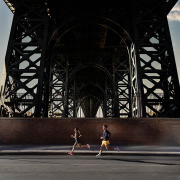 woman and man running under bridge