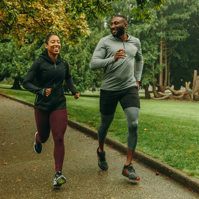 two runners smiling running on a path