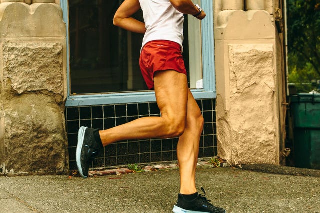 person running on a city sidewalk in athletic wear