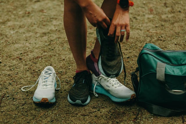 a person changing shoes on a gravel path