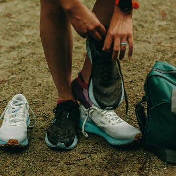 A person changing shoes on a gravel path a person changing shoes on a gravel path