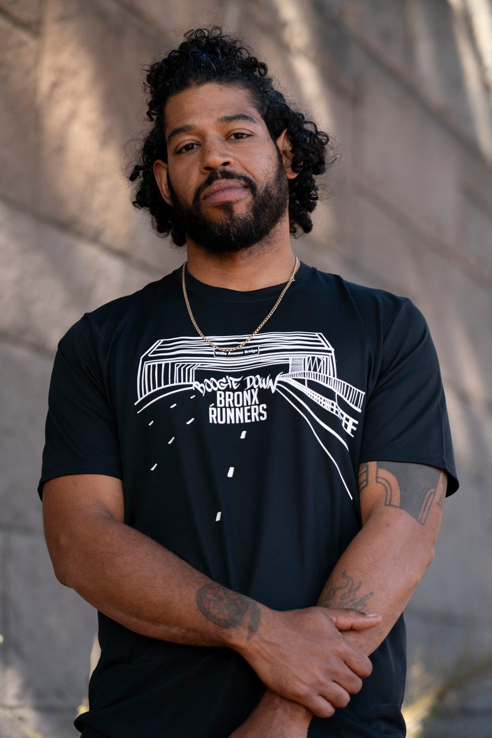 a man poses for a portrait wearing a t shirt reading boogie down bronx runners