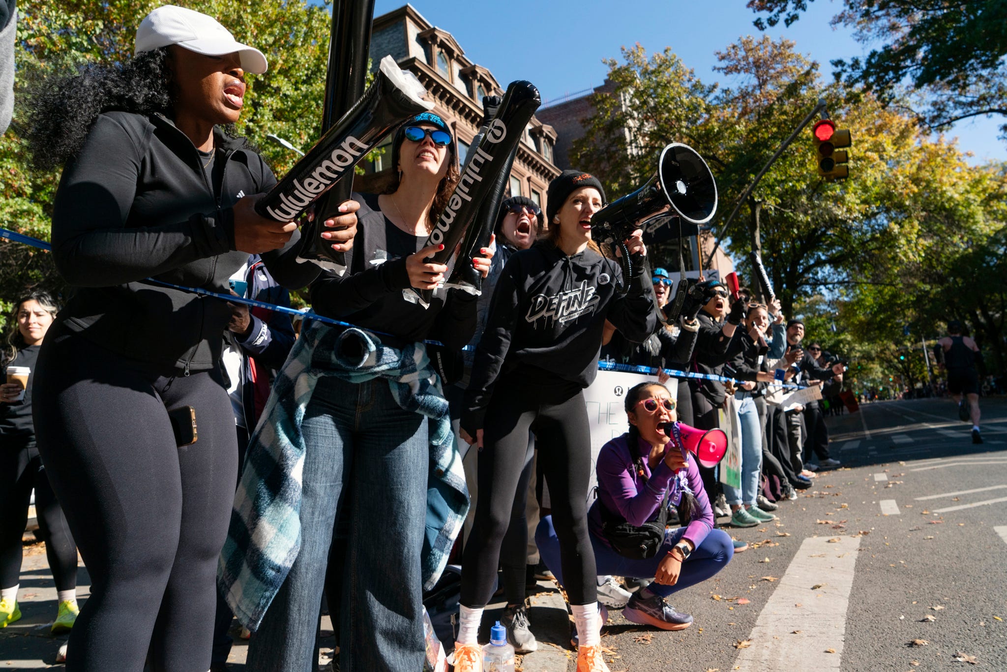 a group of people with megaphones cheering at the side of a city street