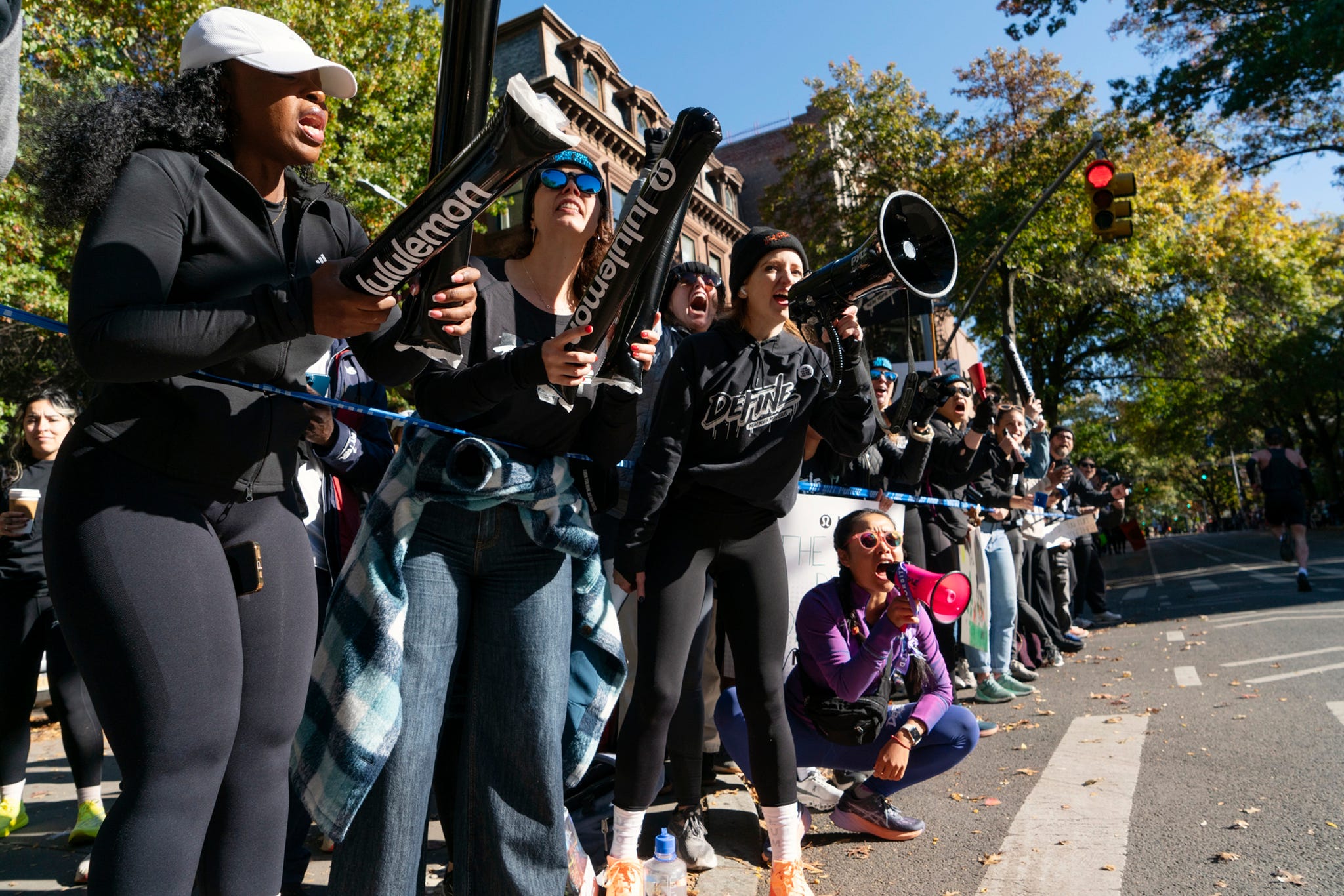 a group of people with megaphones cheering at the side of a city street a group of people with megaphones cheering at the side of a city street