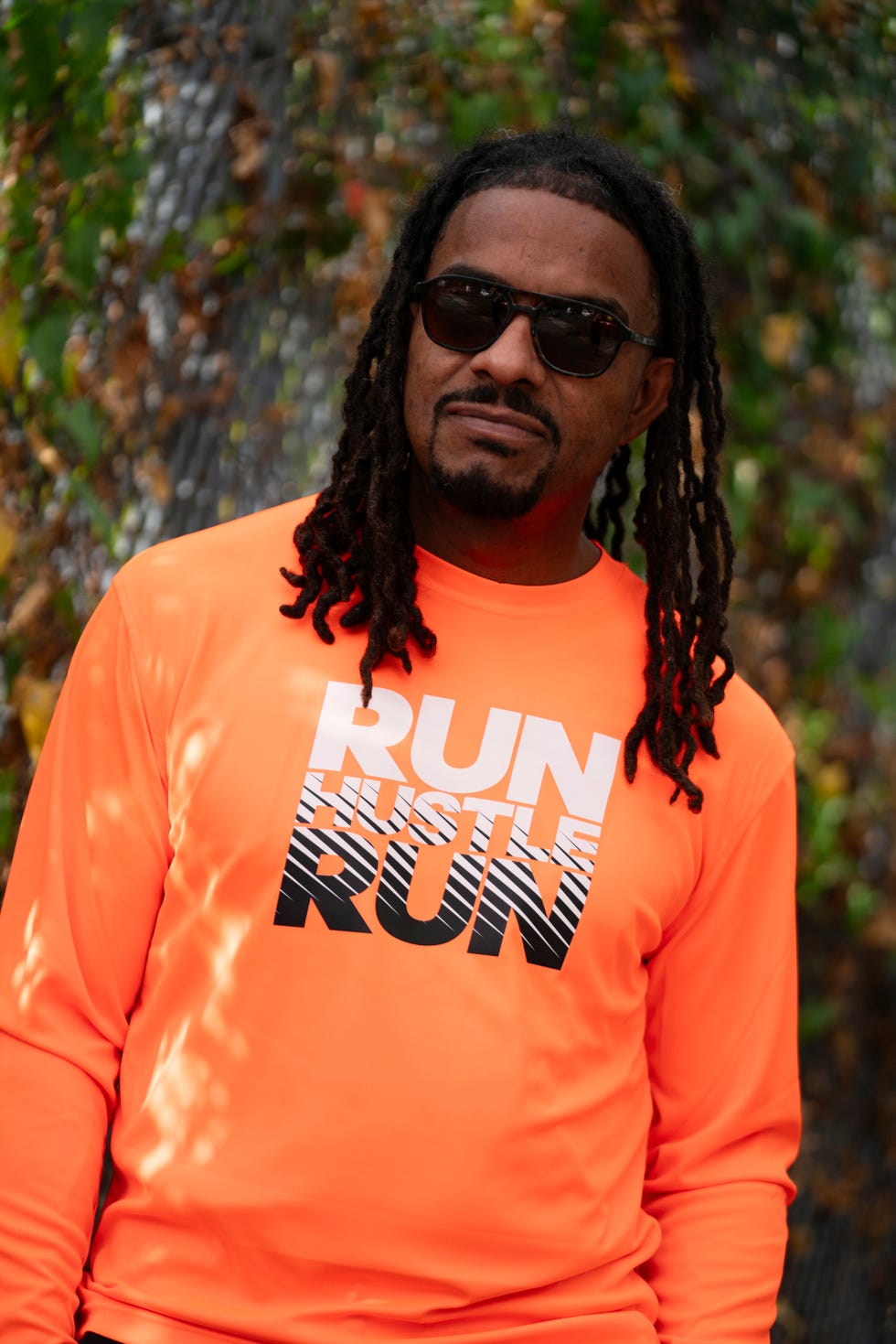 a portrait of a man wearing an orange shirt and sunglasses a portrait of a man wearing an orange shirt and sunglasses