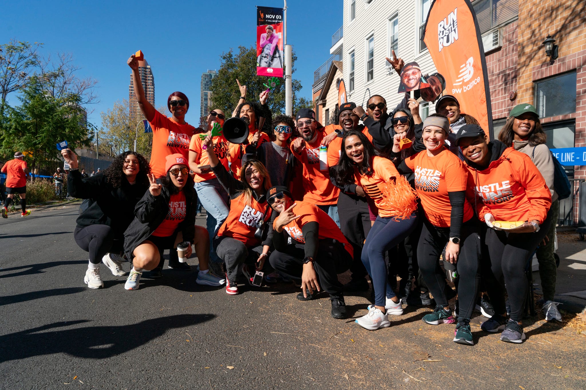 a group of people, many in matching orange shirts, pose for a group photo