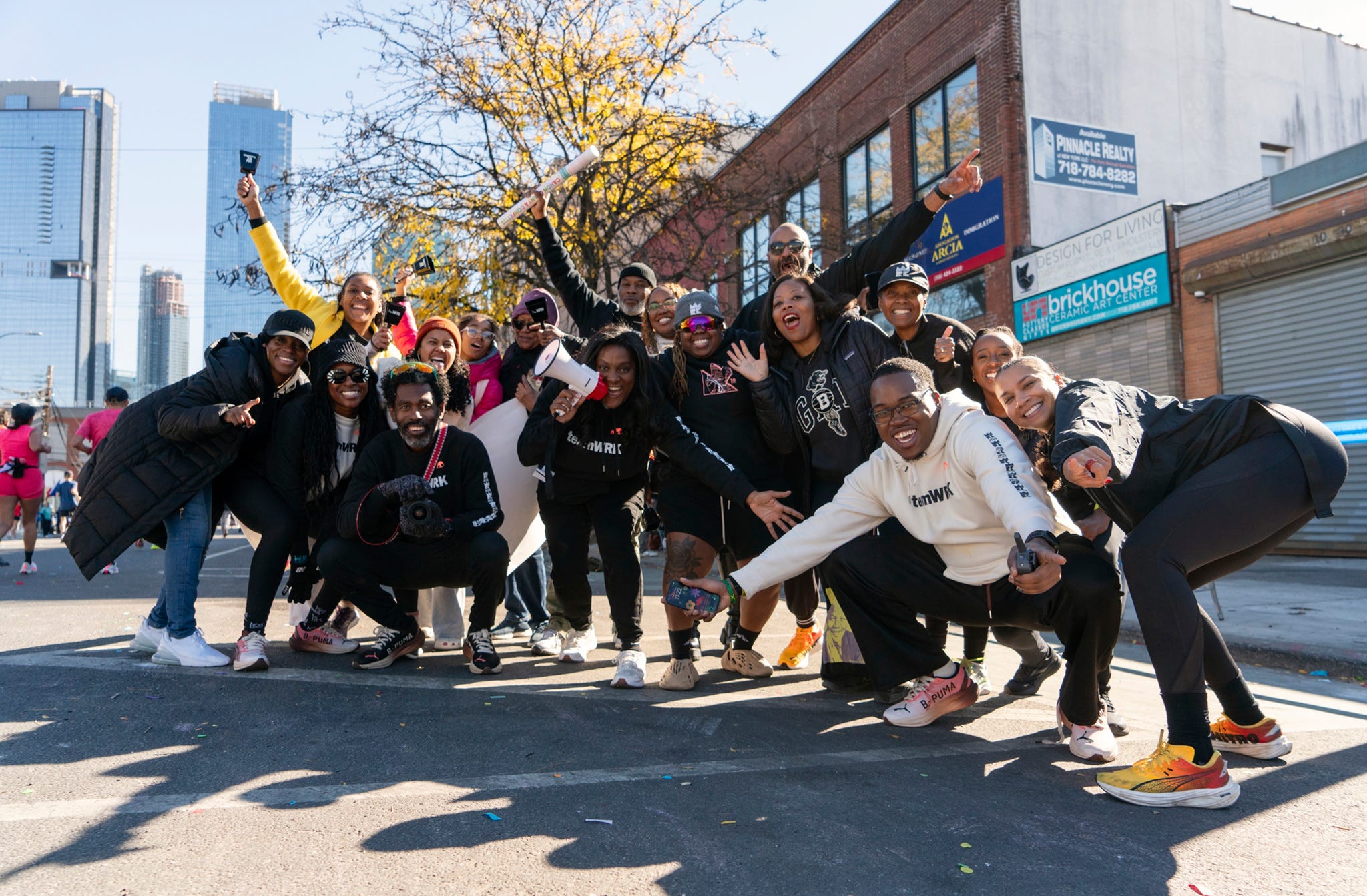 a group of people cheer as they pose for a group photo