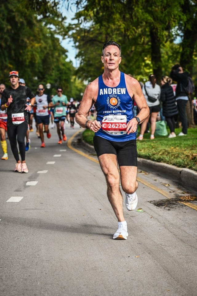 a man running on a road with people watching andrew macphail