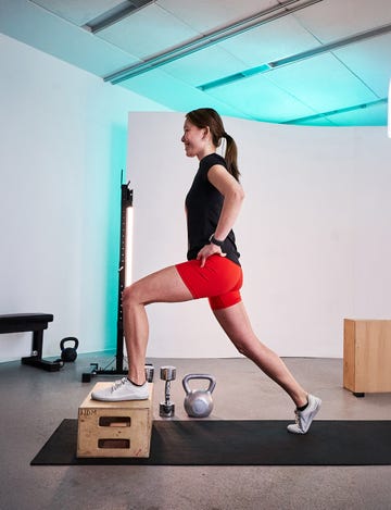 individual performing a lunge on a plyometric box in a gym setting