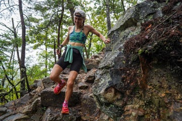 a woman trail runner descending a rocky trail