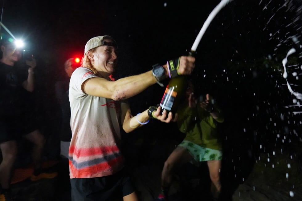 a runner celebrates with a bottle of champagne