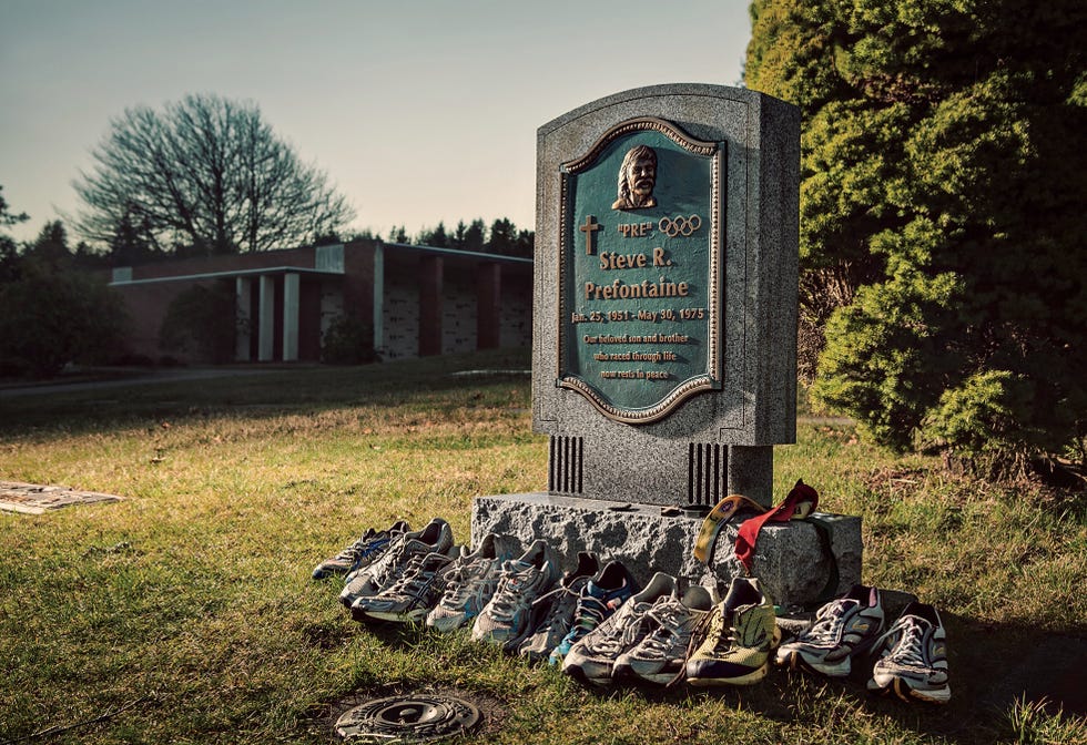 a tombstone with running shoes at the foot of it