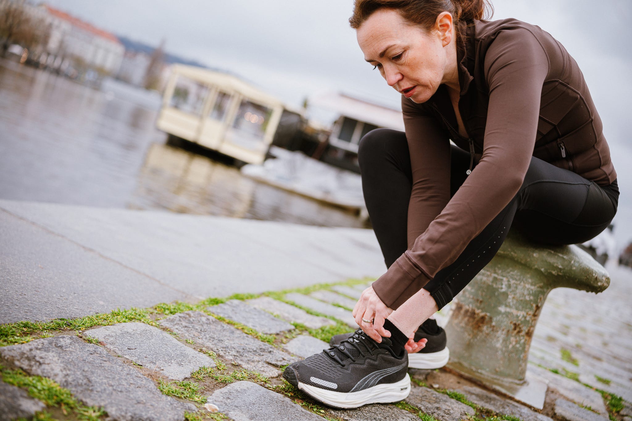 Individual tying shoelaces while seated outdoors