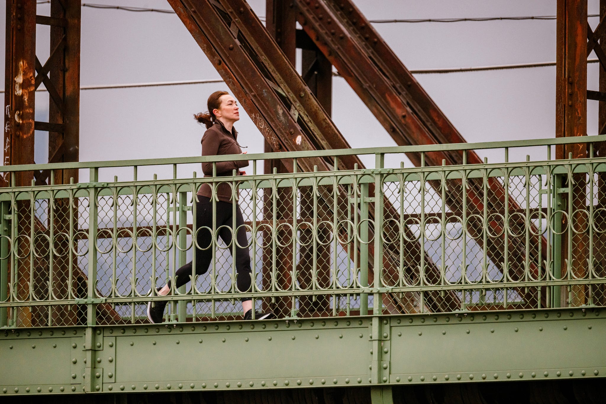 a woman runs across a bridge
