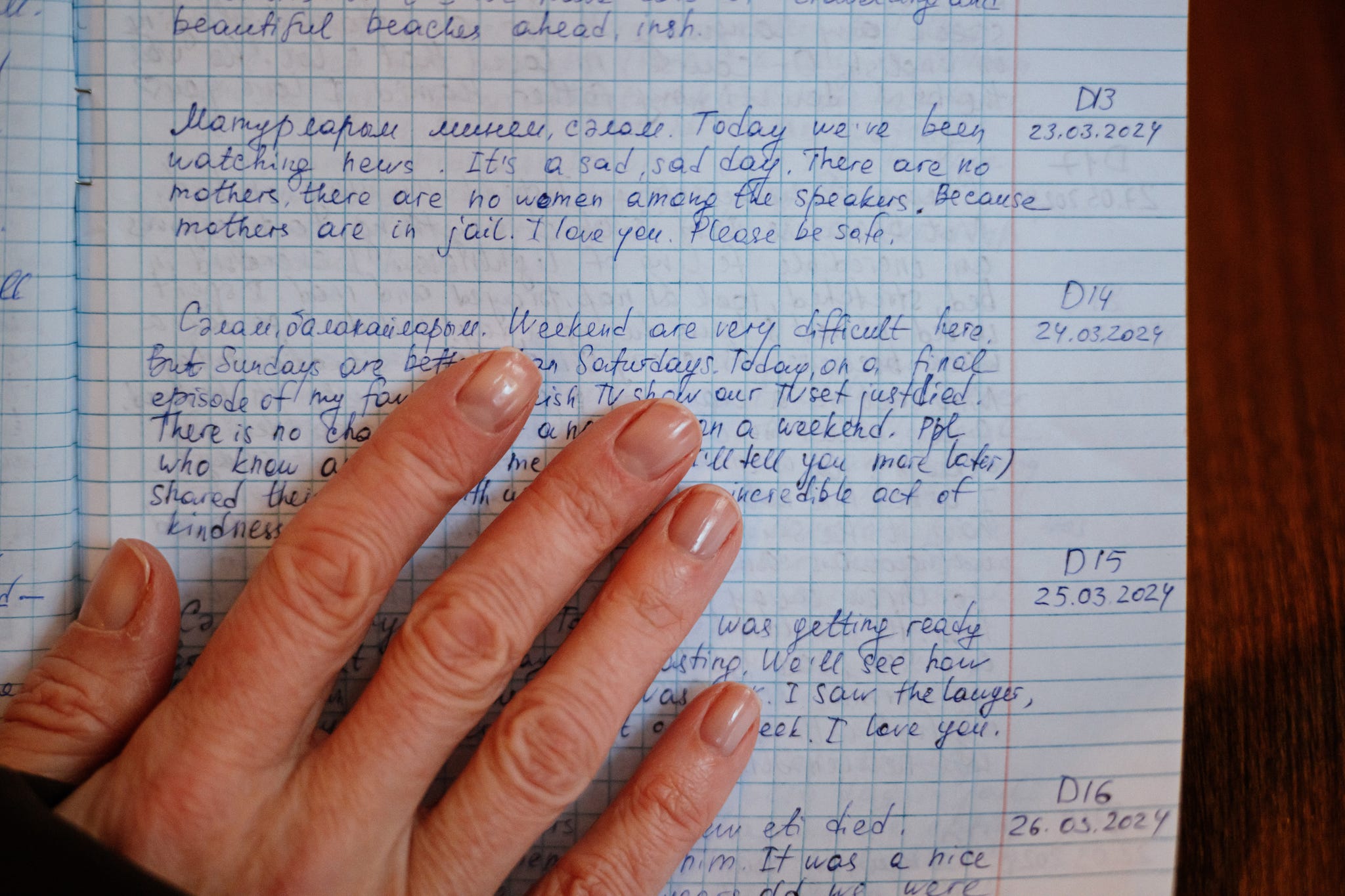 a hand covers a page of a diary