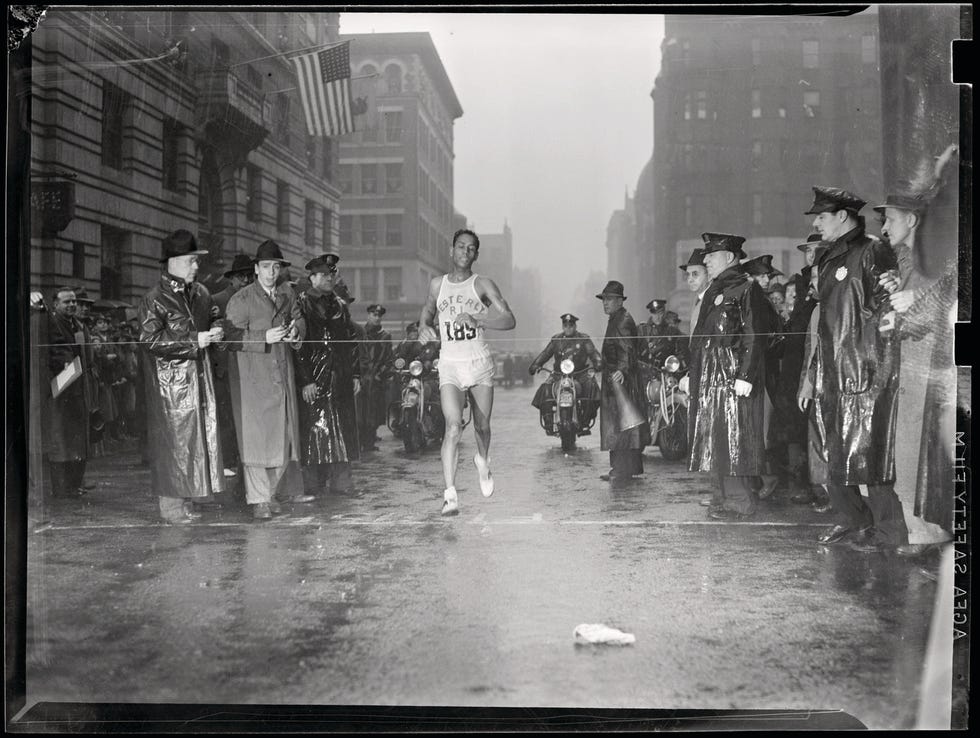 runner finishing a marathon amid a crowd of onlookers and police