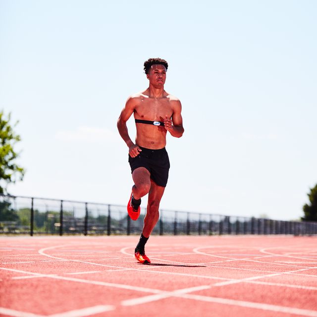man running on a track with a heart rate monitor