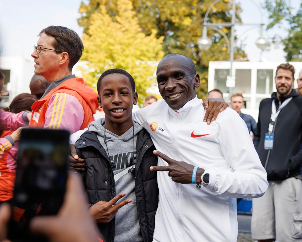 posing with a fan after winning the 2022 berlin marathon