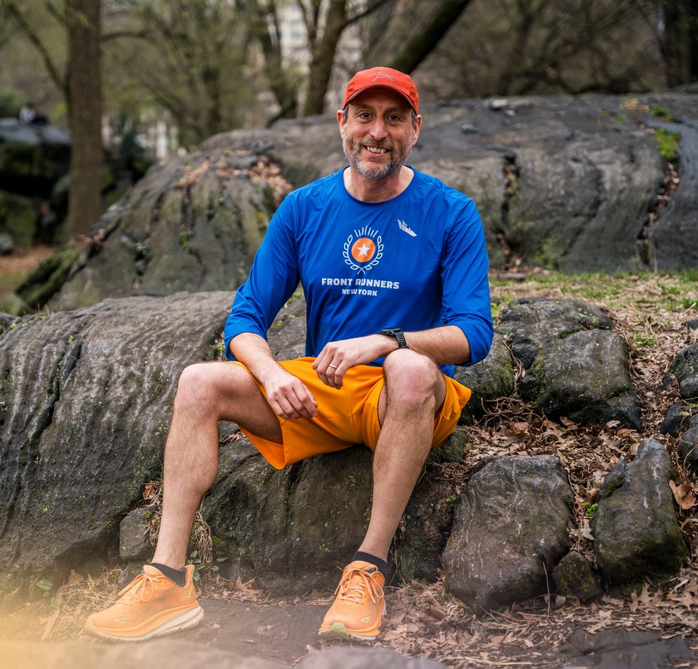 Person in athletic clothing resting on rocks in a park