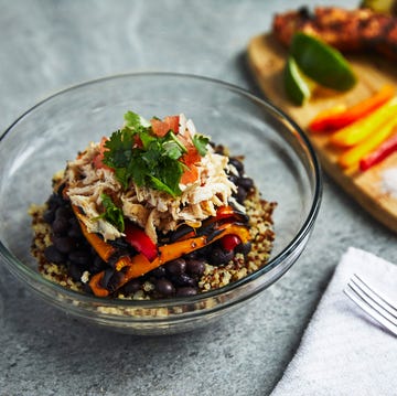 a rice bowl with the ingredients laid out sit on a table