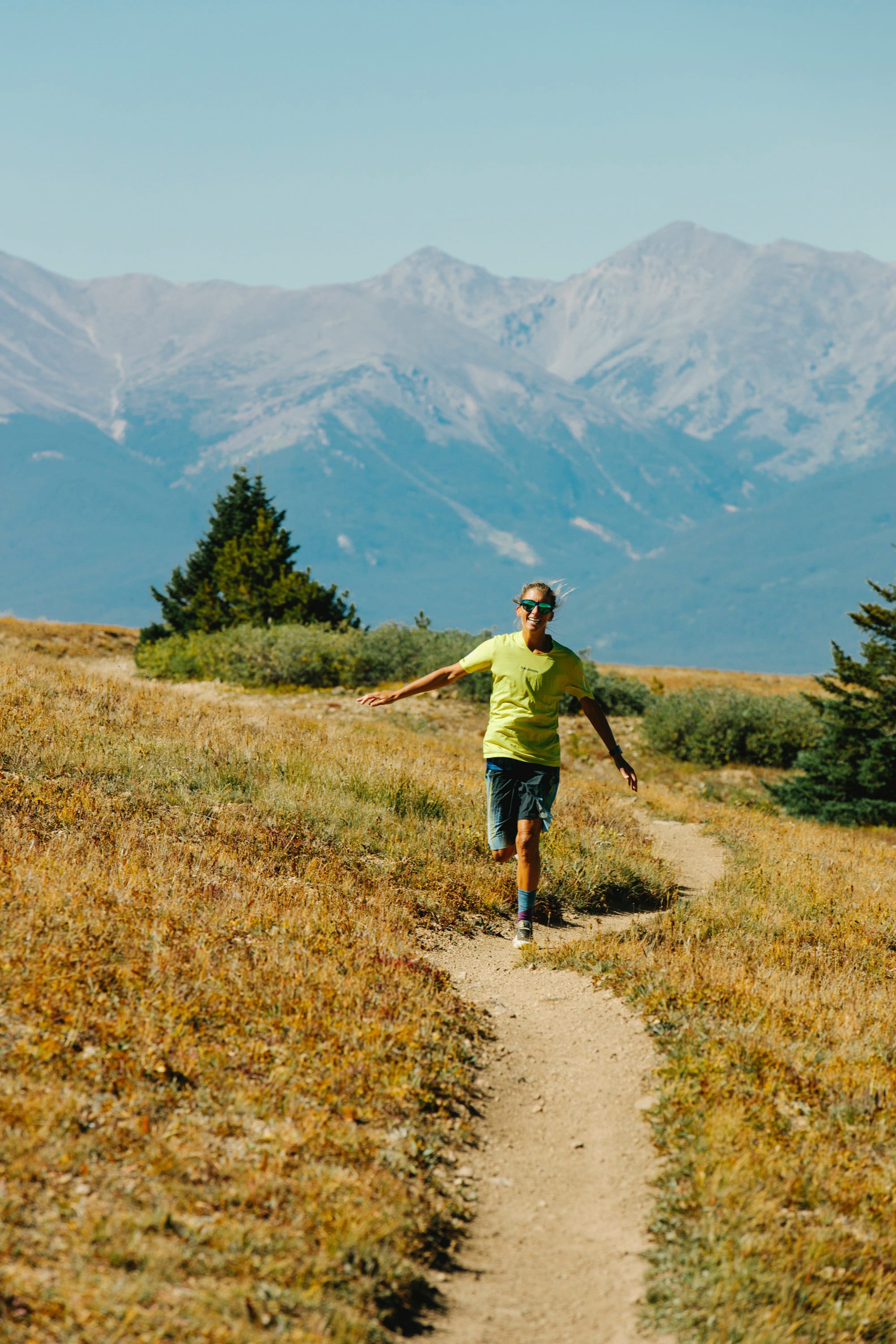 Child running along a trail with mountains in the background