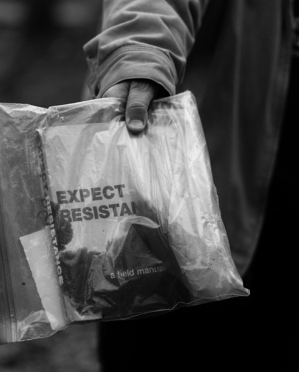 a person holds a clear bag with a book inside