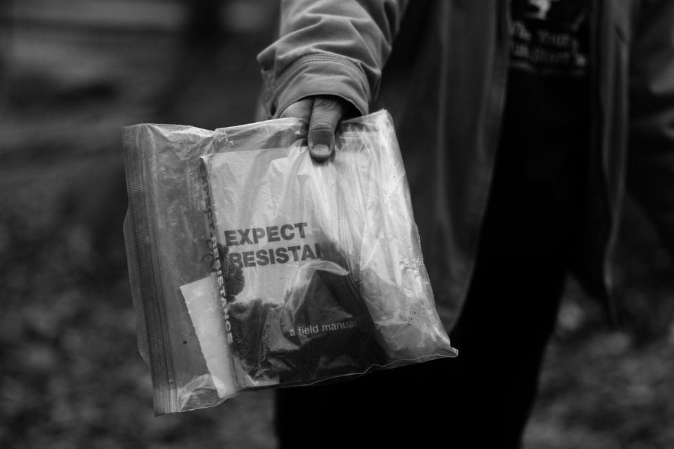 a person holds a clear bag with a book inside