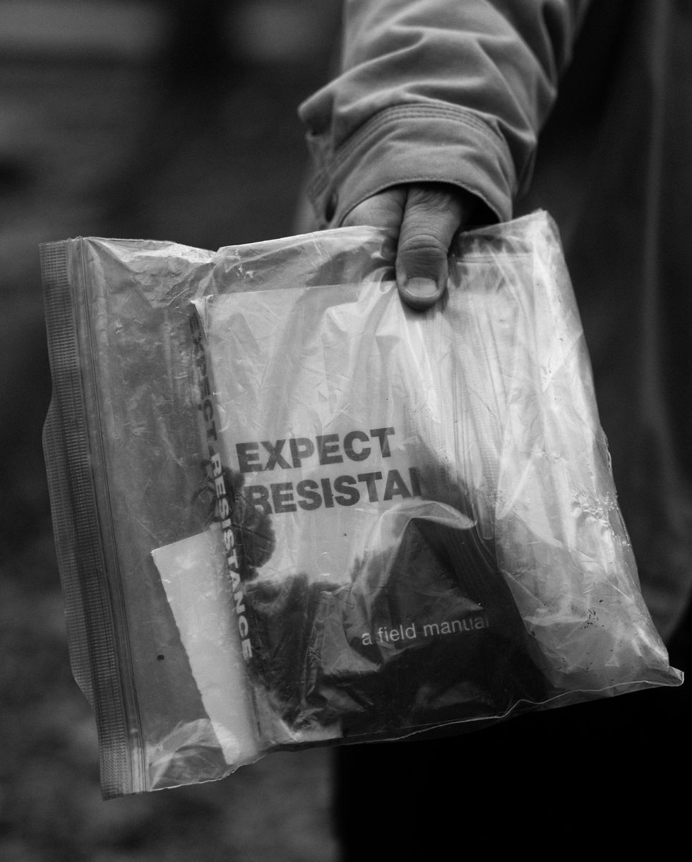 a person holds a clear bag with a book inside