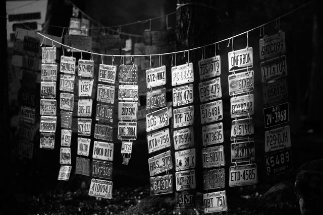 a collection of license plates hang on a string