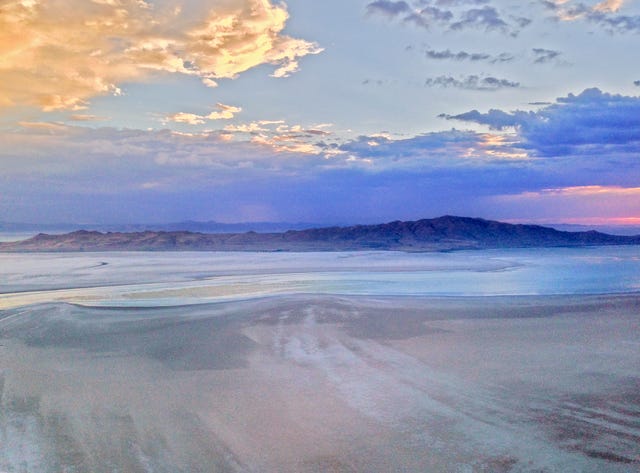 a sunset glows over great salt lake and antelope island near salt lake city, utah, the remnants of ancient bonneville lake that once covered most of the state, reckoning with the west, land, delta
