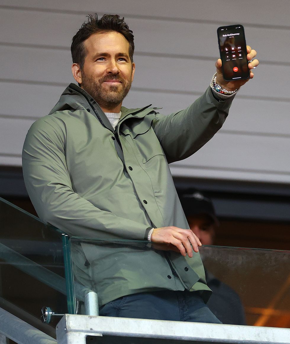 ryan reynolds holding up a cell phone showing rob mcelhenney as the other caller