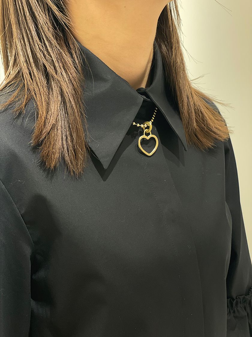 a person wearing a black shirt and a gold necklace
