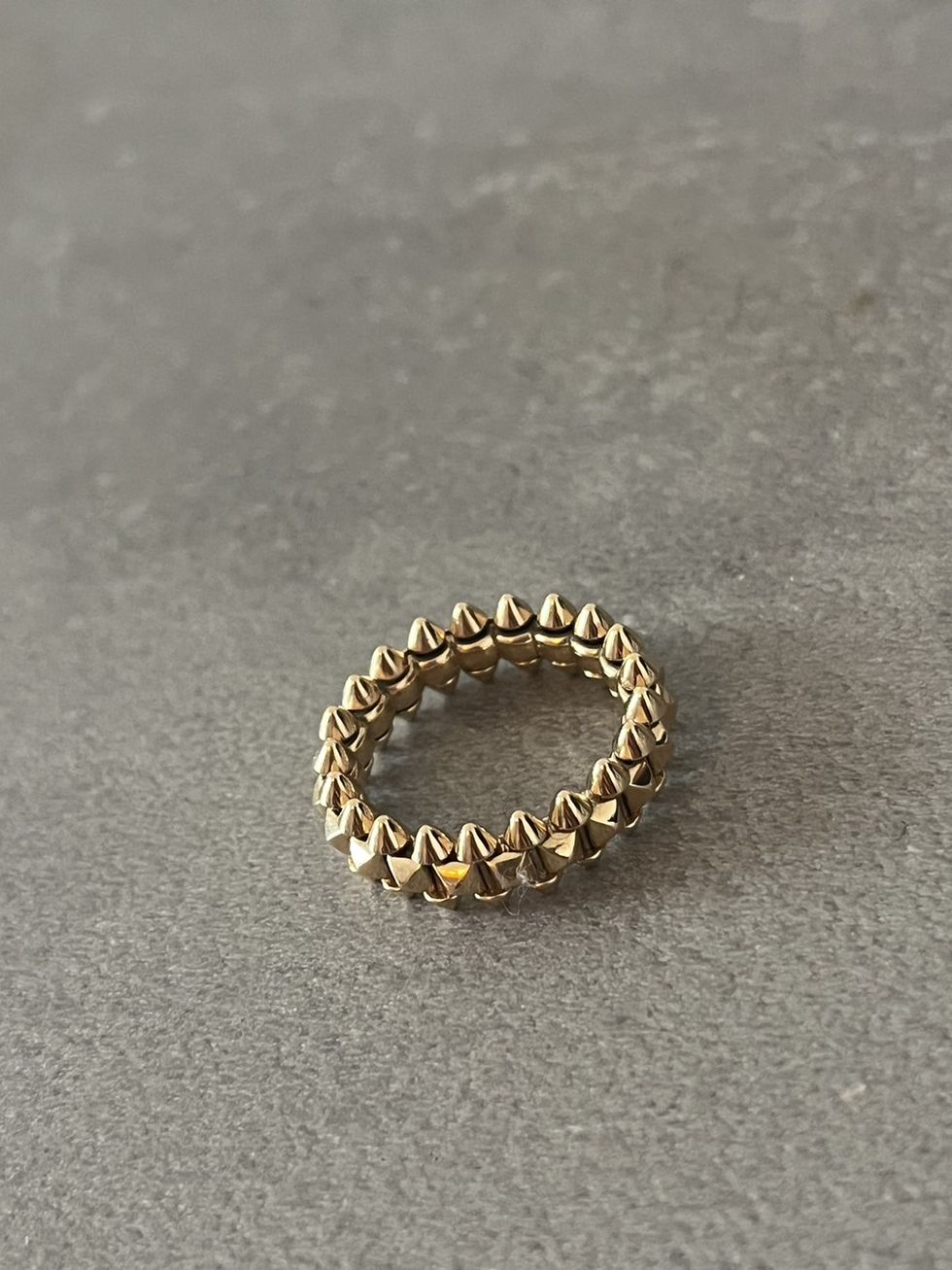 a gold ring on a grey surface