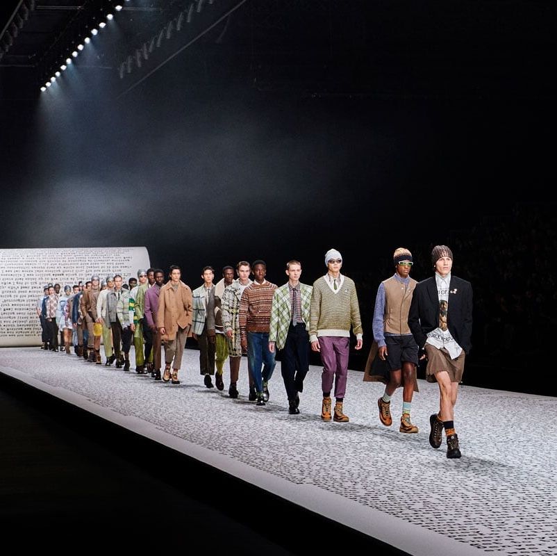 a group of people walking on a runway