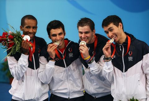 jason rogers and his olympic fencing team biting their silver medals